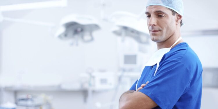 A male surgeon standing in an operating room. - mybiked.com